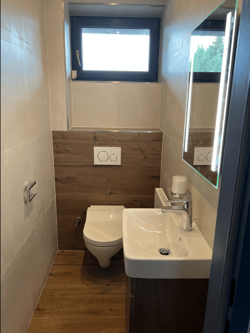 Ein Badezimmer mit Toilette, Waschbecken und Spiegel.