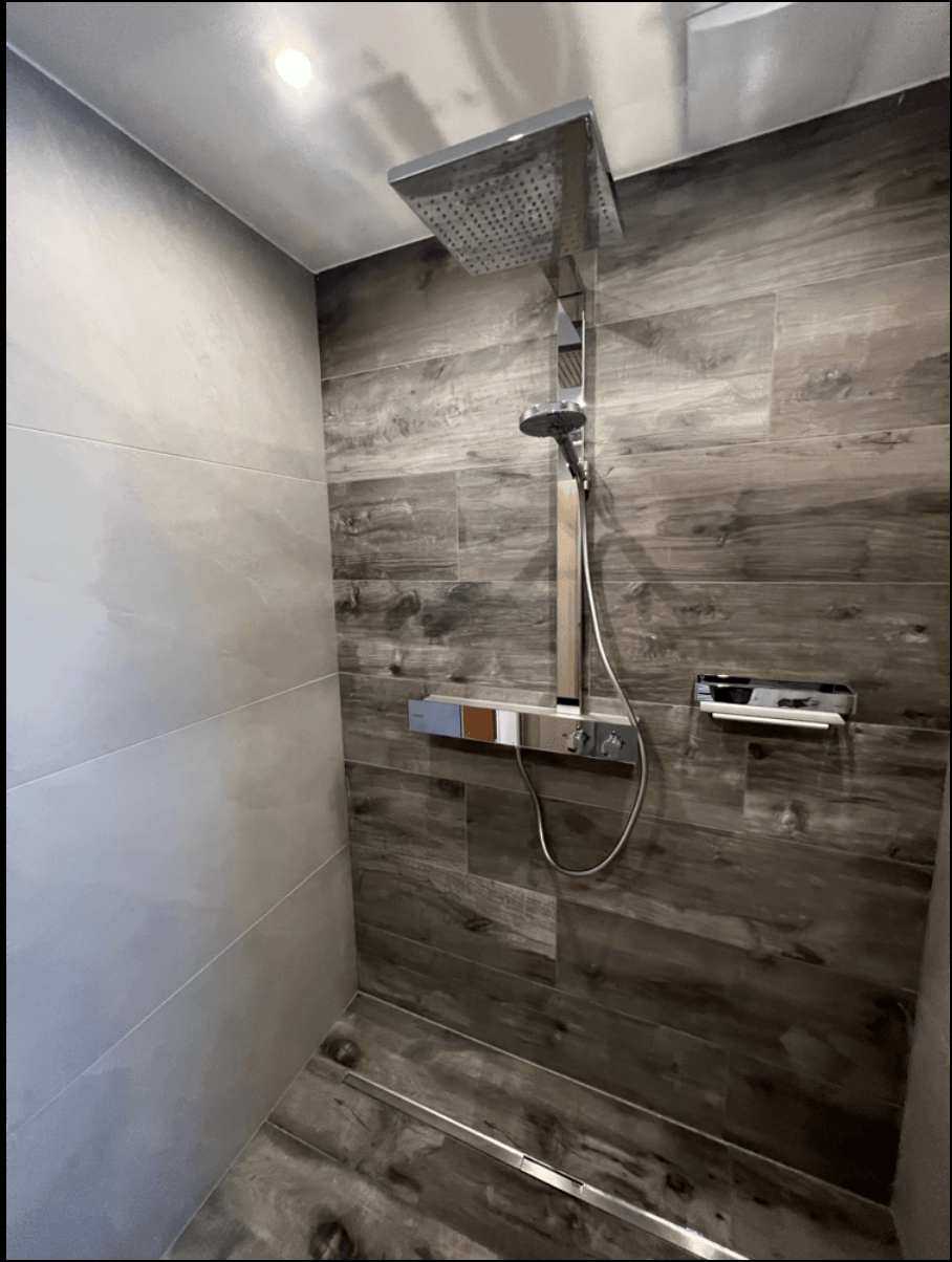 Eine Dusche mit Holzwand und Duschkopf.