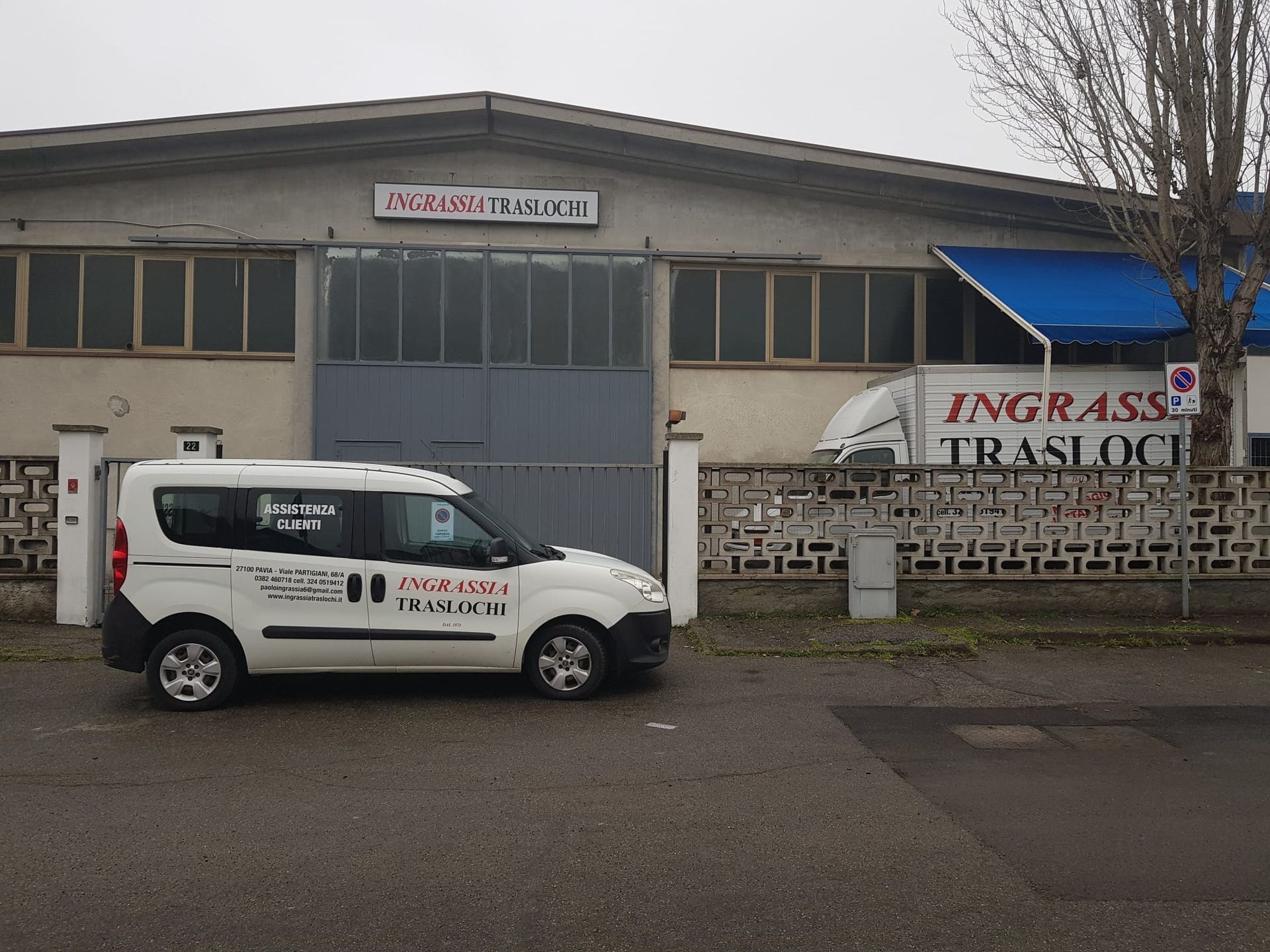 Furgone bianco parcheggiato fuori da un edificio con la scritta 