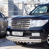 A black toyota land cruiser is parked next to a silver car.