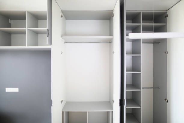 Empty white and gray closet with multiple compartments and shelves.