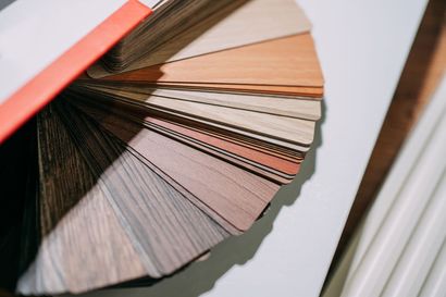 Fan of wood veneer color samples in various shades.