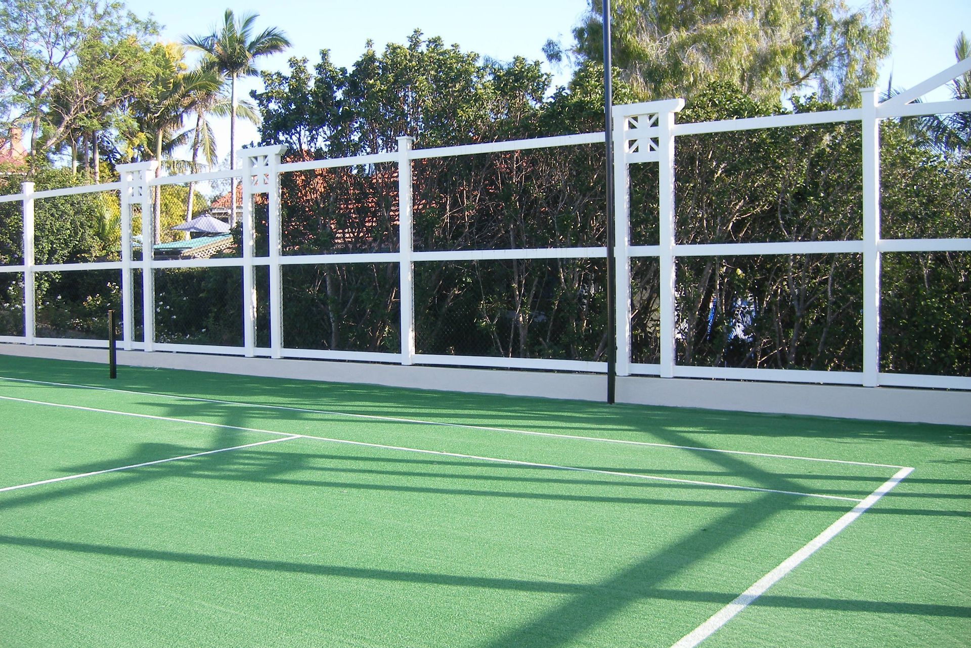 Tennis Court with a White Fence and Trees in the Background — Queensland, Australia — Jordin Sports Constructions