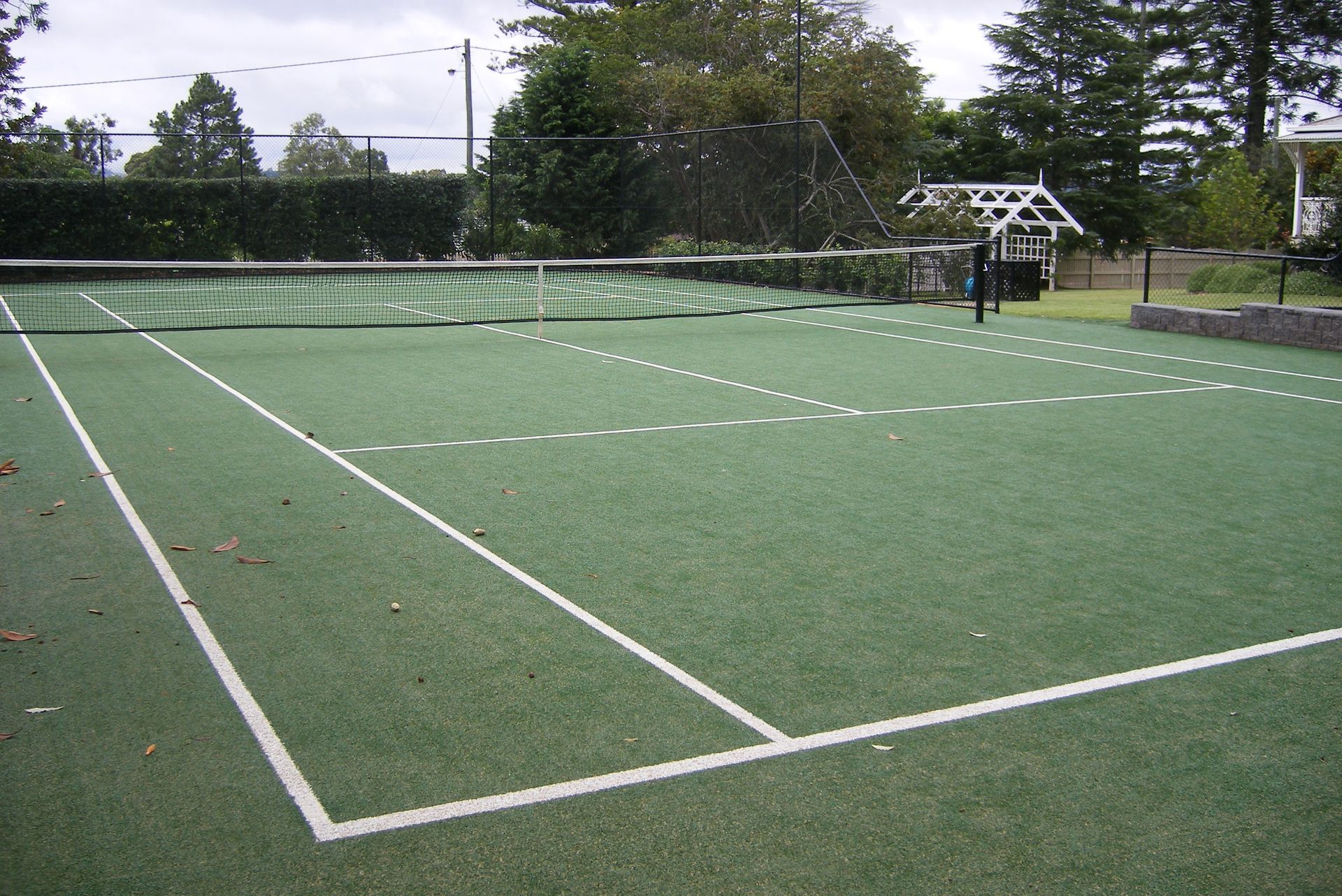 Green Tennis Court with and Trees in the Background — Queensland, Australia — Jordin Sports Constructions