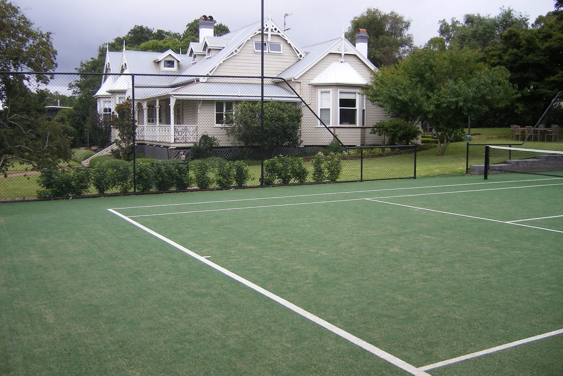 Tennis Court with a White House in the Background — Queensland, Australia — Jordin Sports Constructions