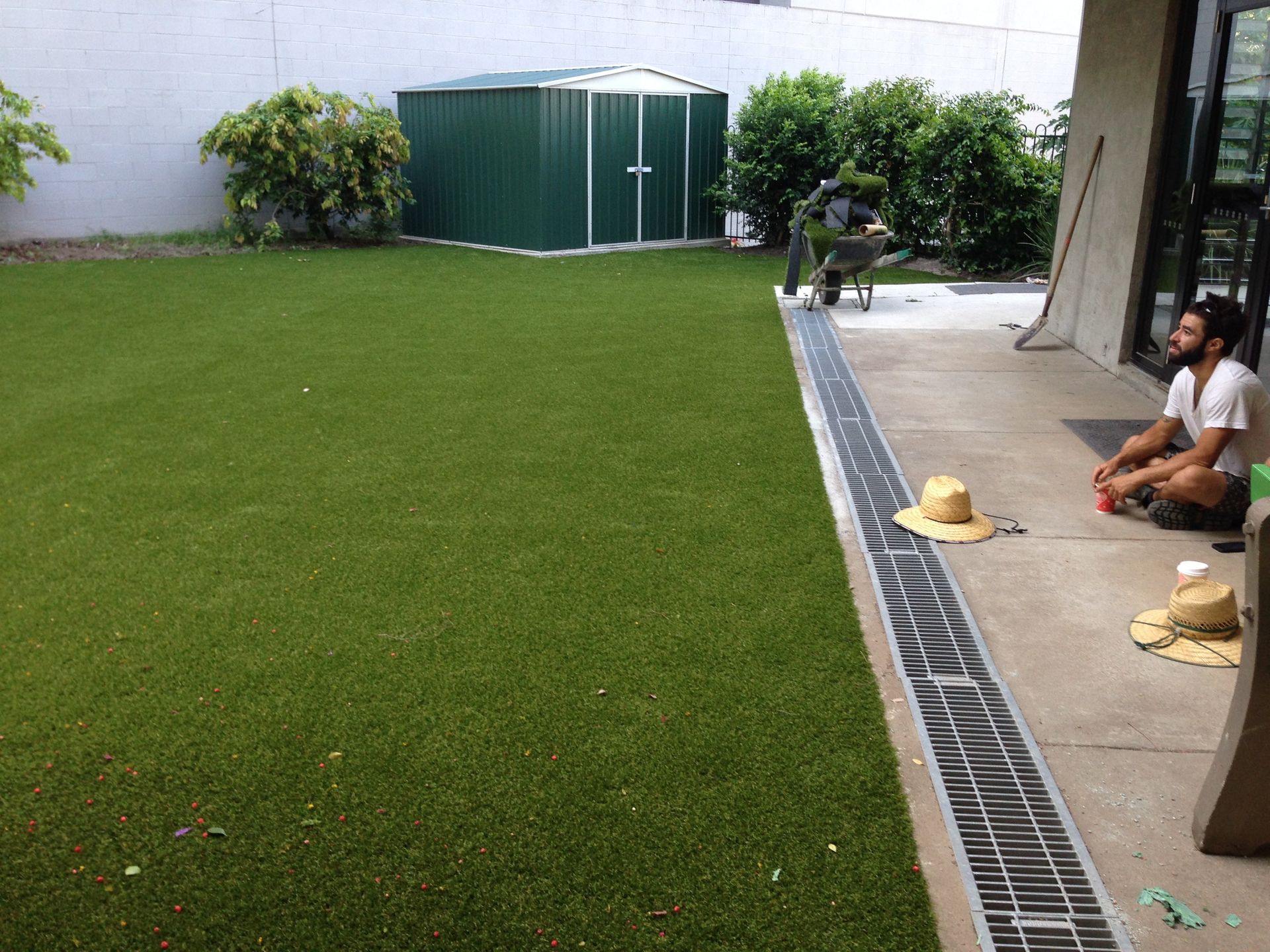 Two Men Sitting on a Patio in Front of a Green Shed — Queensland, Australia — Jordin Sports Constructions