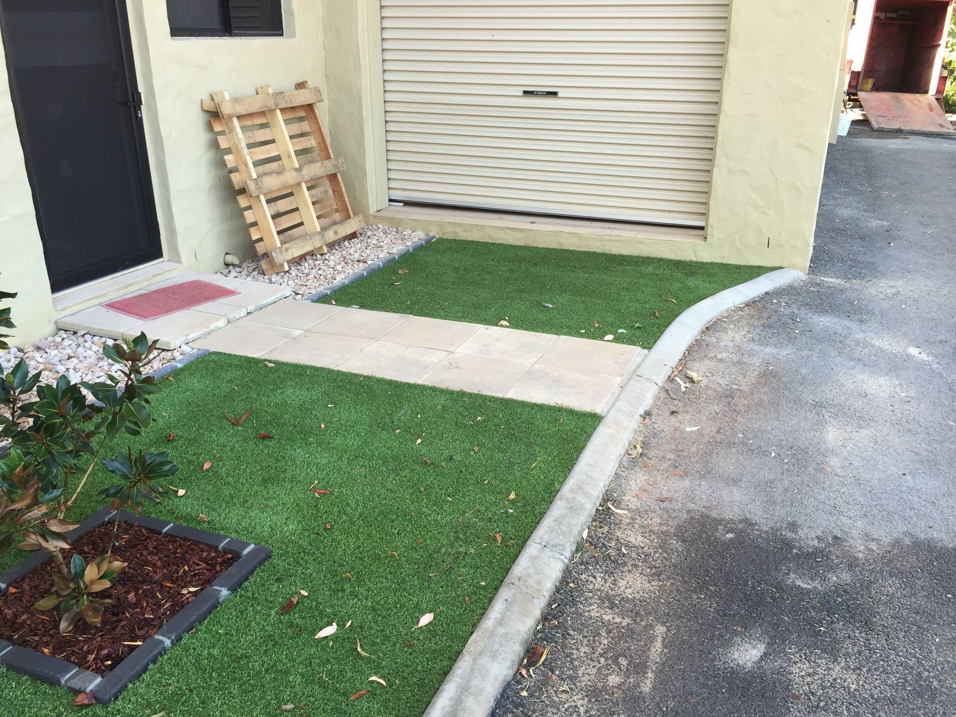 A Wooden Pallet in the Grass in Front of a Garage Door — Queensland, Australia — Jordin Sports Constructions