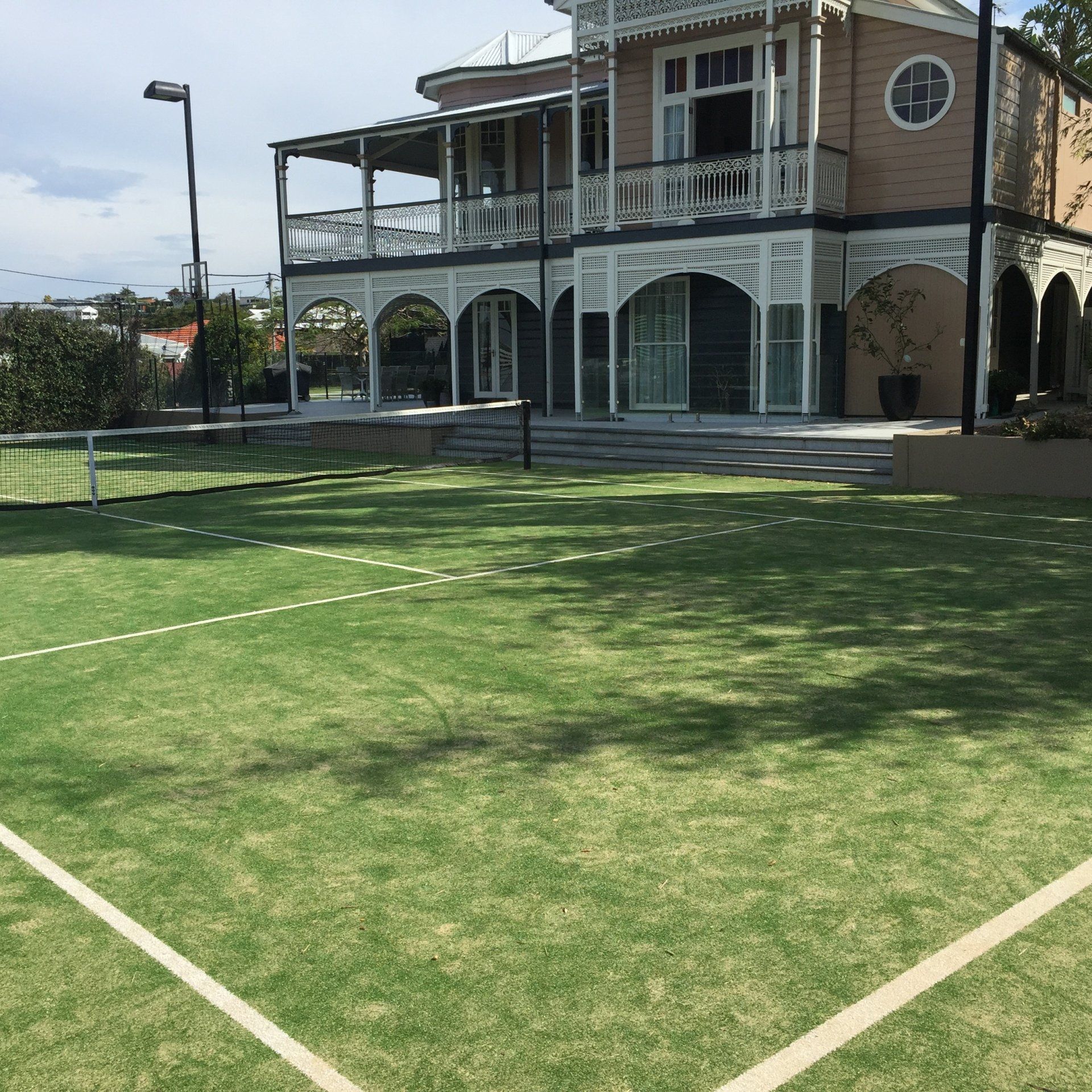 A Large House with a Tennis Court in Front of It — Queensland, Australia — Jordin Sports Constructions