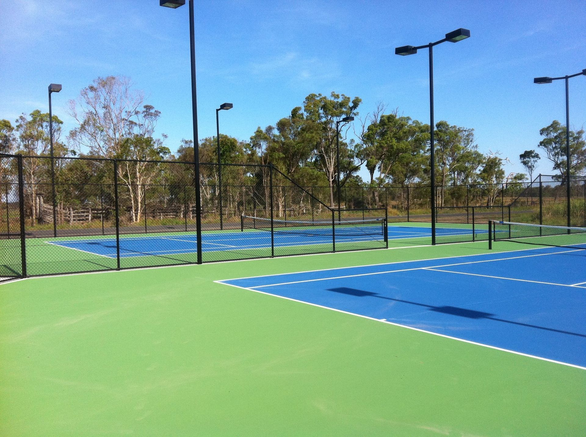 Row of Tennis Courts with Trees in the Background — Queensland, Australia — Jordin Sports Constructions