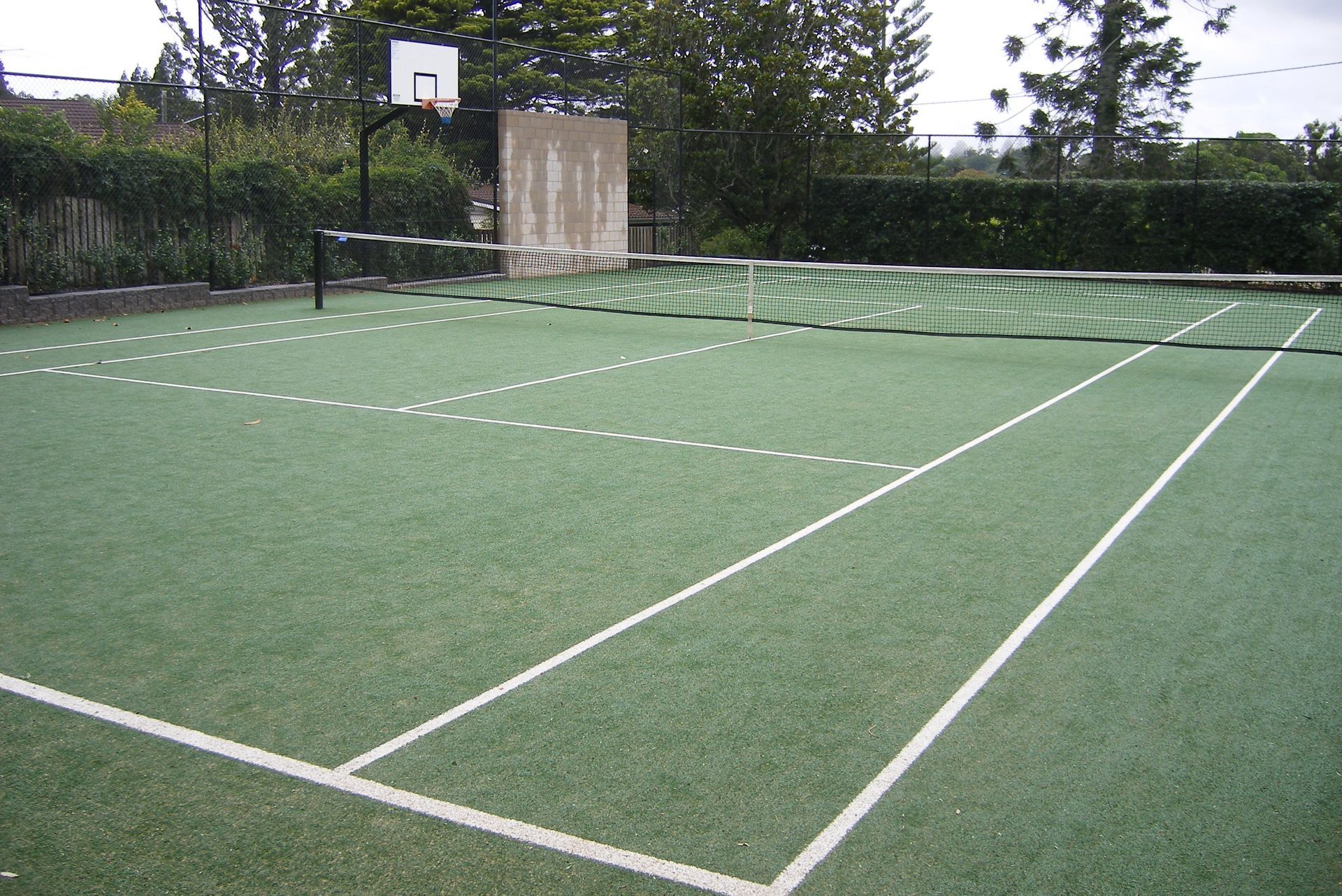 A Tennis Court with a Basketball Hoop in the Background — Queensland, Australia — Jordin Sports Constructions