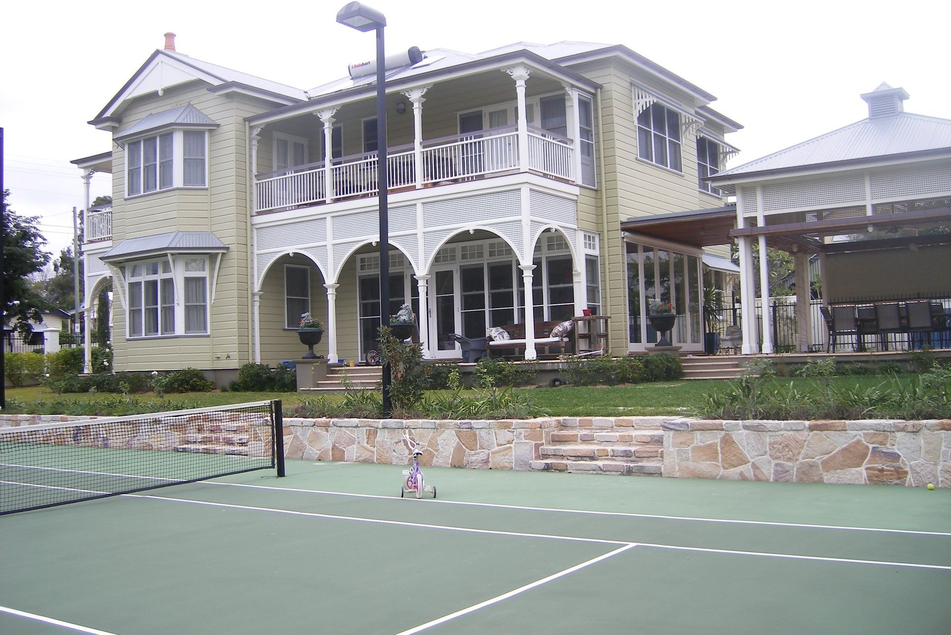 Large White House with a Tennis Court in Front of It — Queensland, Australia — Jordin Sports Constructions