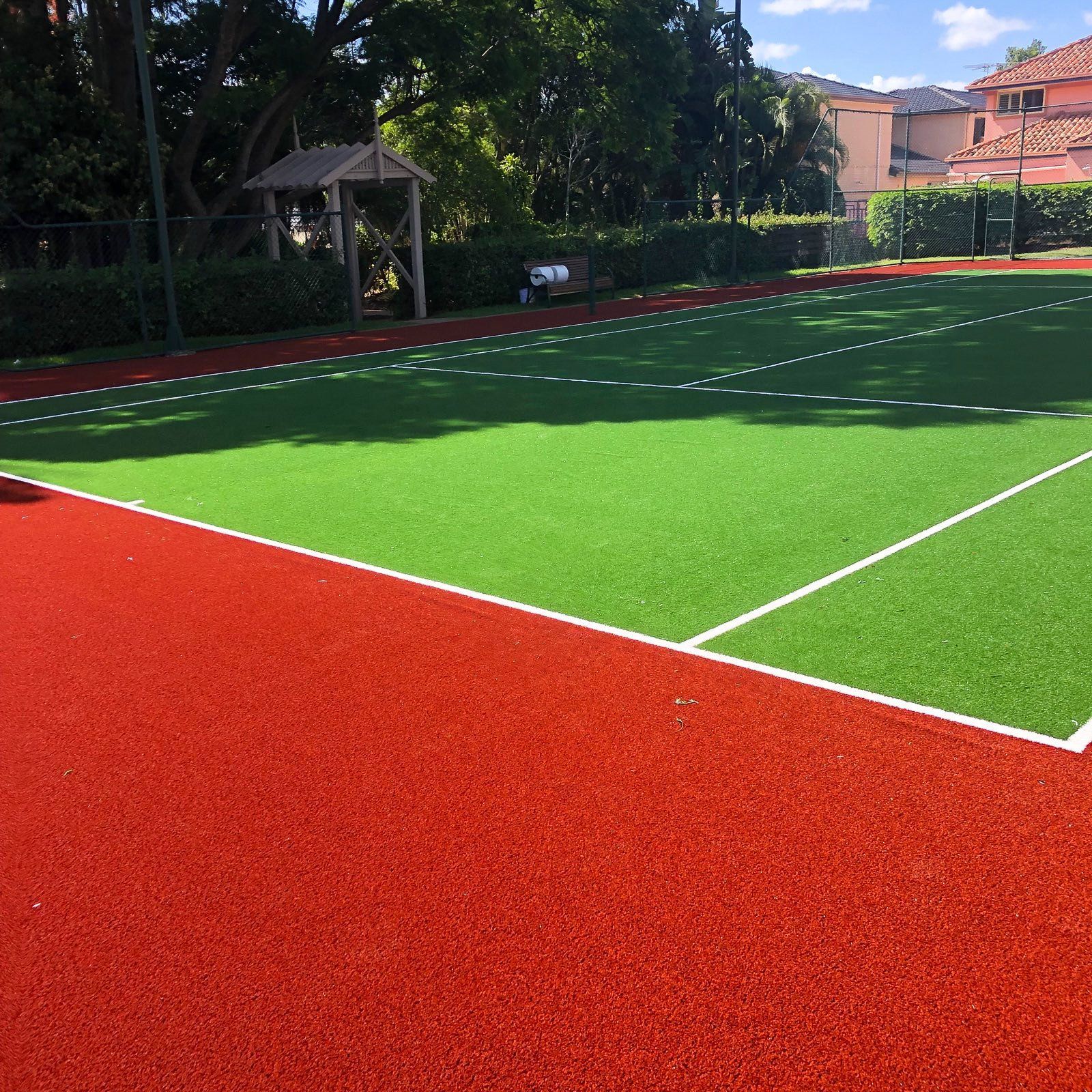 A Tennis Court with Green Grass and Red Rubber — Queensland, Australia — Jordin Sports Constructions