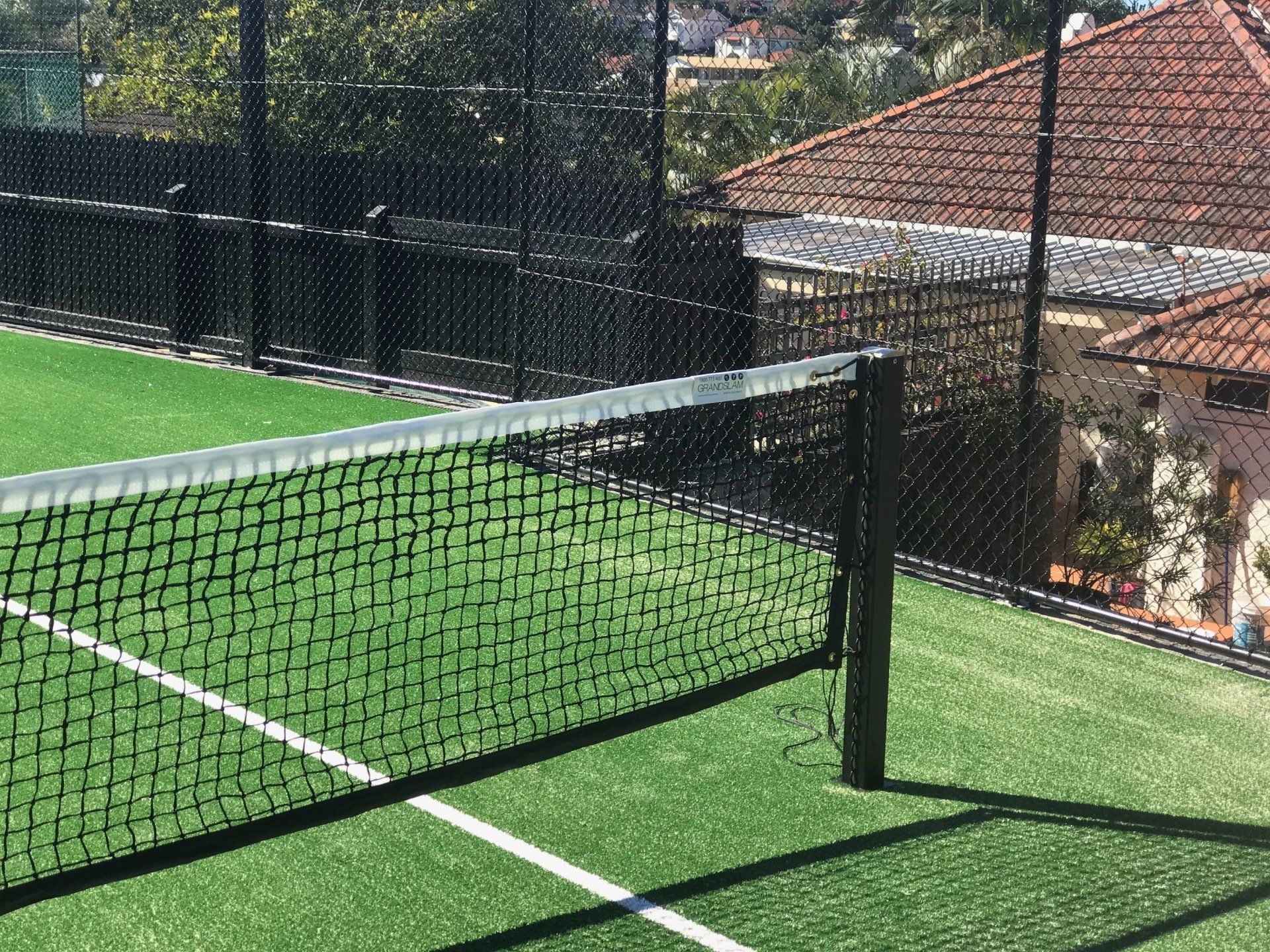 Tennis Court with a Fence Around it and a House in the Background — Queensland, Australia — Jordin Sports Constructions