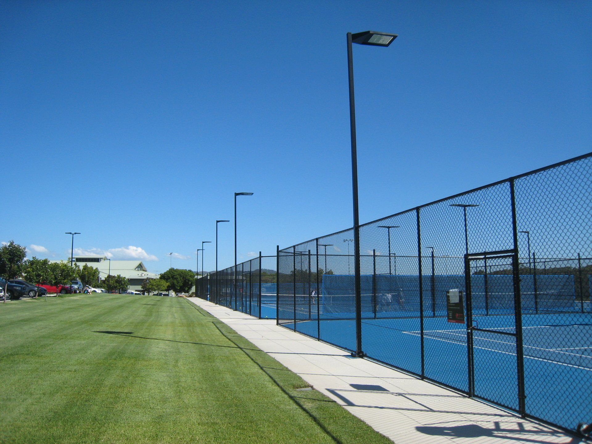 A Tennis Court with a Chain Link Fence Surrounding It — Queensland, Australia — Jordin Sports Constructions