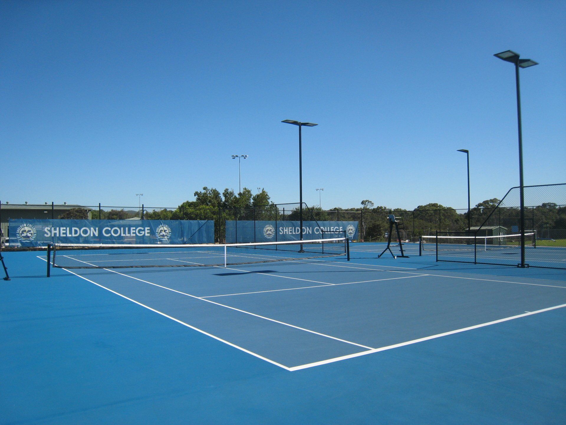 Tennis Court with a Sign that Says Sheldon College — Queensland, Australia — Jordin Sports Constructions