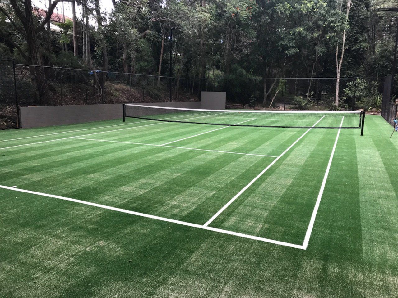 A Tennis Court with a Net in the Middle of It — Queensland, Australia — Jordin Sports Constructions