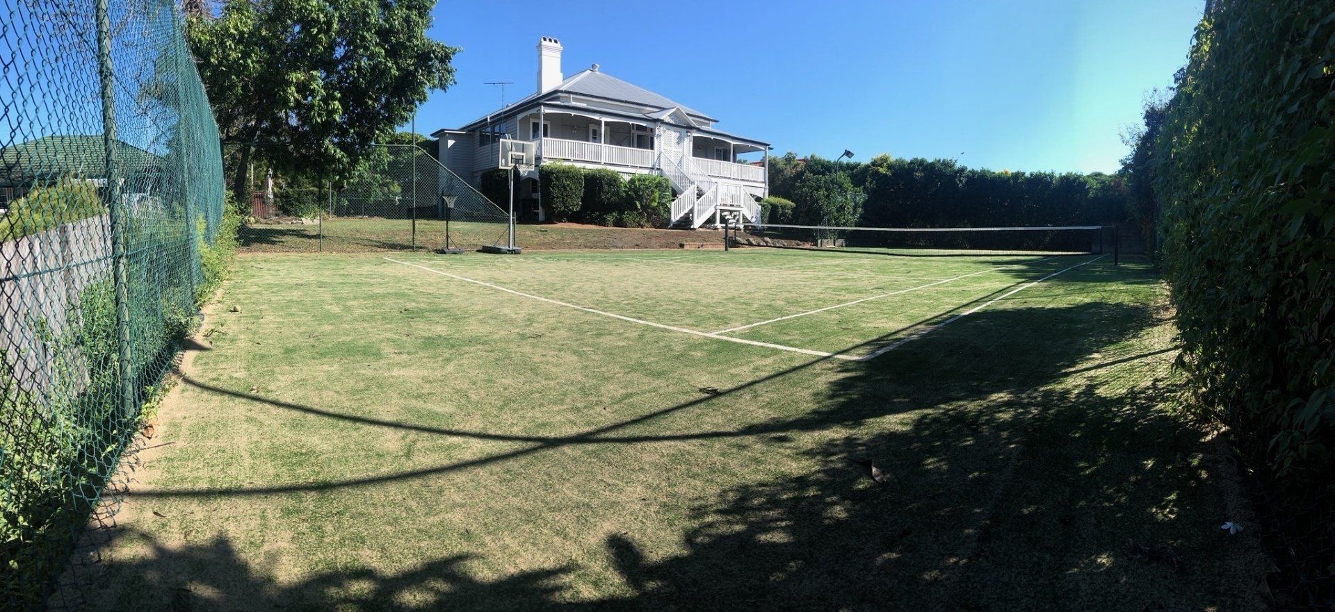 Large House Behind a Fence and a Lush Green Field — Queensland, Australia — Jordin Sports Constructions