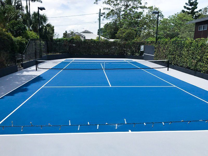 Blue and White Tennis Court with Trees in the Background — Queensland, Australia — Jordin Sports Constructions