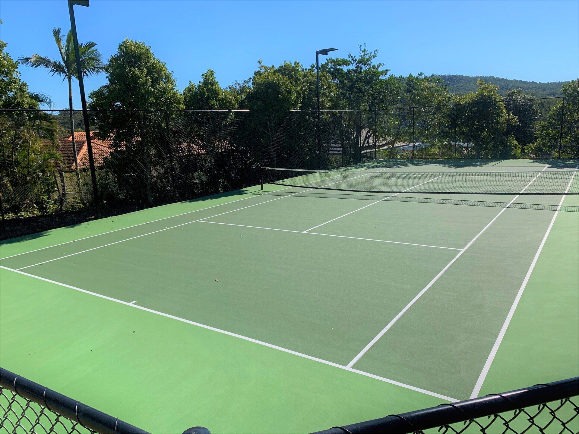 Tennis Court Surrounded by Trees and a Chain-Link Fence — Queensland, Australia — Jordin Sports Constructions