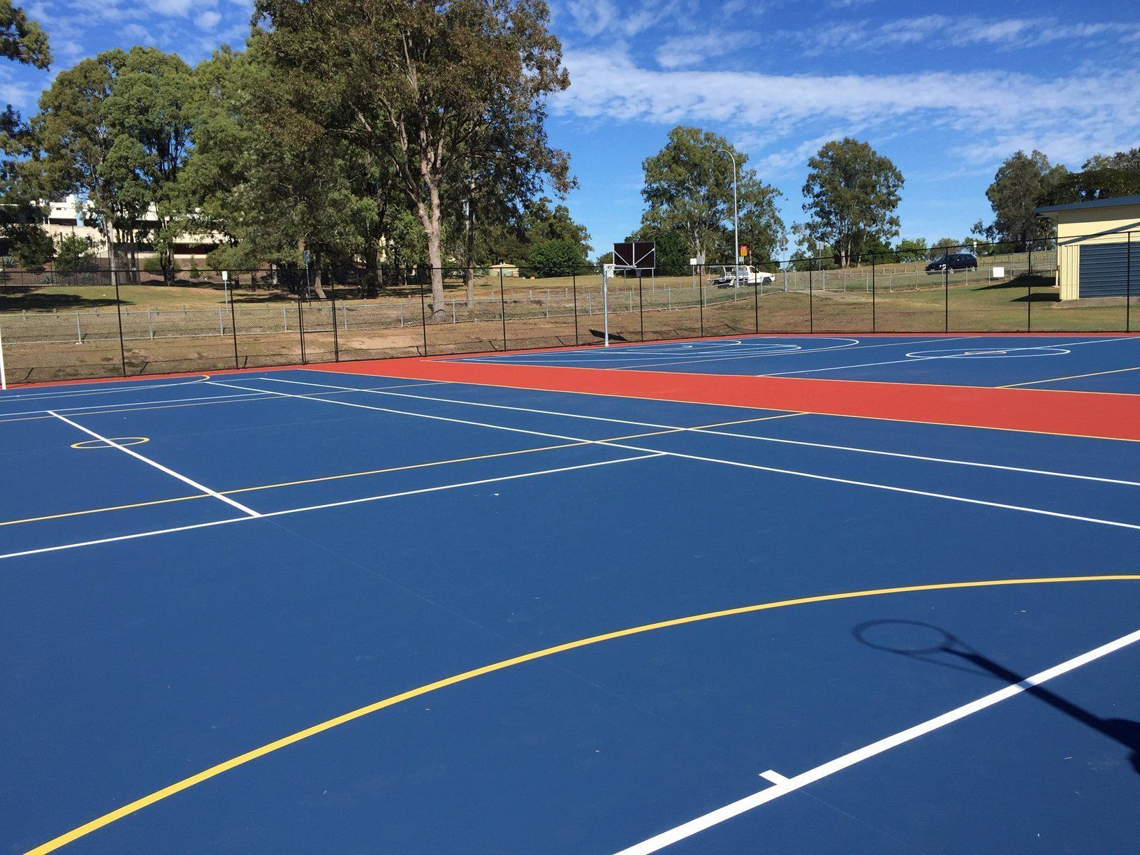 Blue and Red Basketball Court with Trees in the Background — Queensland, Australia — Jordin Sports Constructions