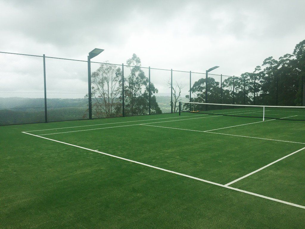 A Tennis Court with a Fence and Trees — Queensland, Australia — Jordin Sports Constructions