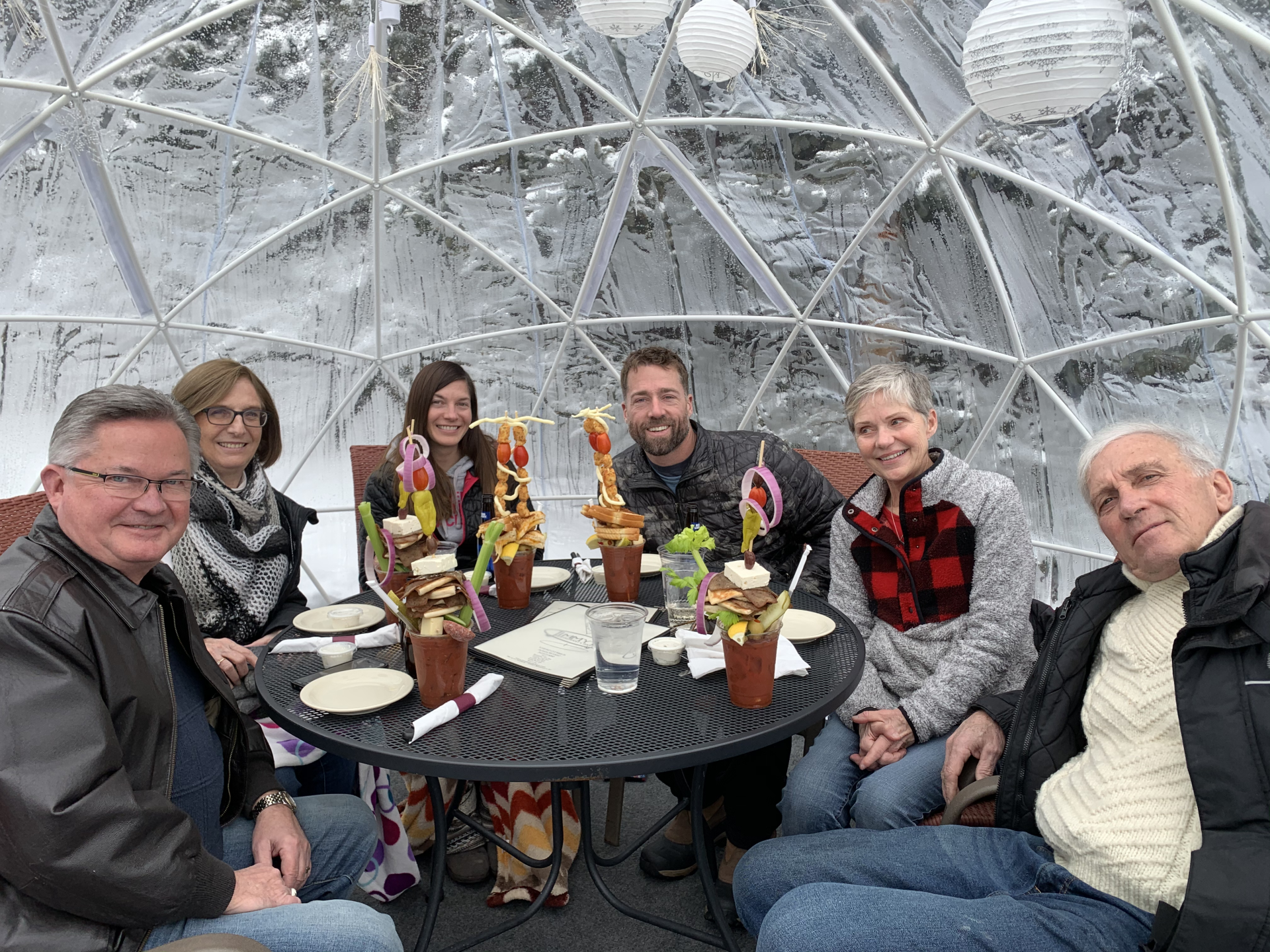 A group of people are sitting around a table in a dome.