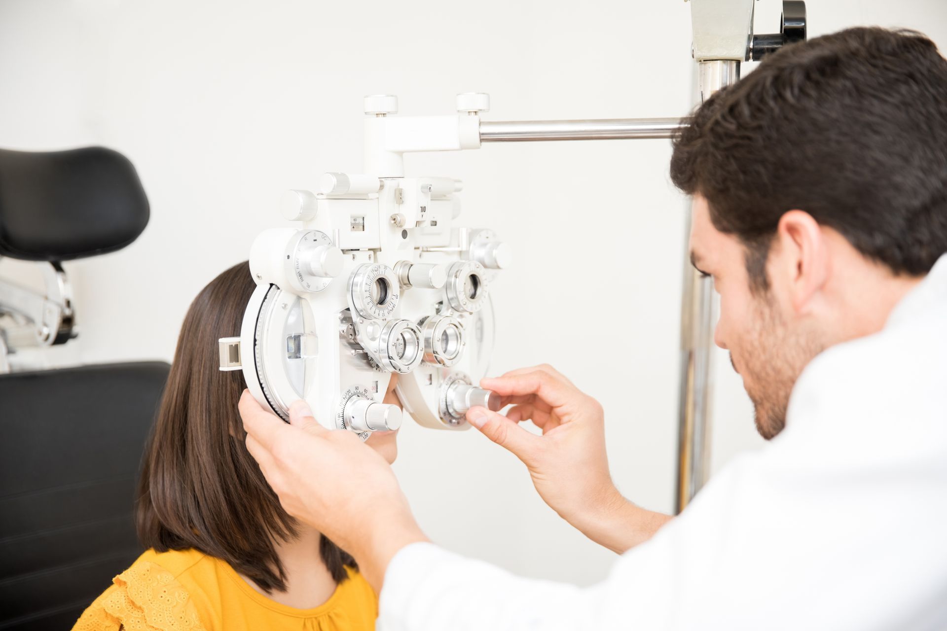 An optometrist is doing sight testing for a patient in the clinic.