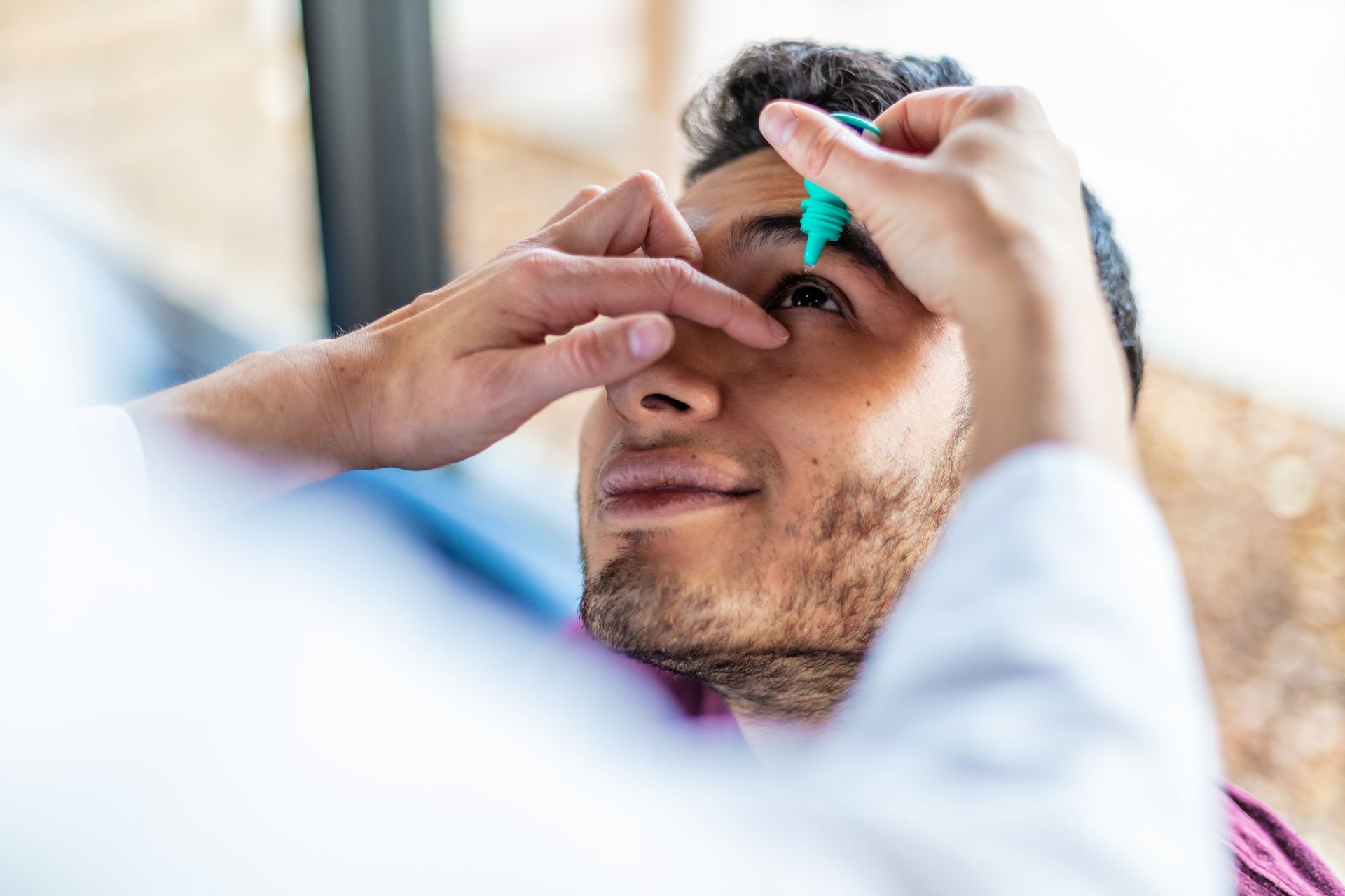 Eyecare professional using eye drops in eyecare clinic. Eyecare professional using eye drops in eyecare clinic.