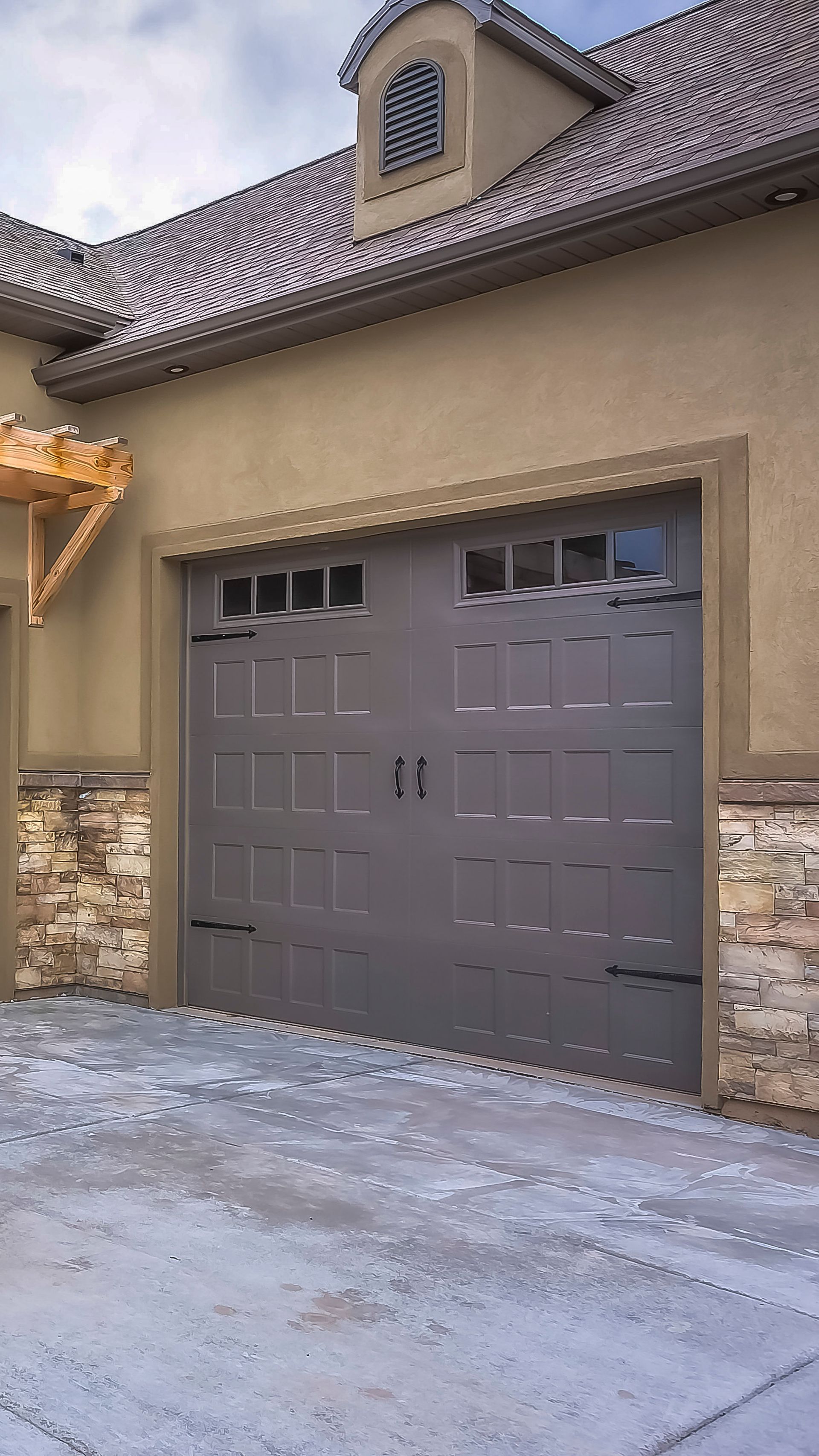 A large garage door is sitting in front of a house.