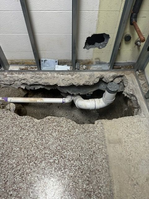 A hole in the floor with a pipe coming out of it