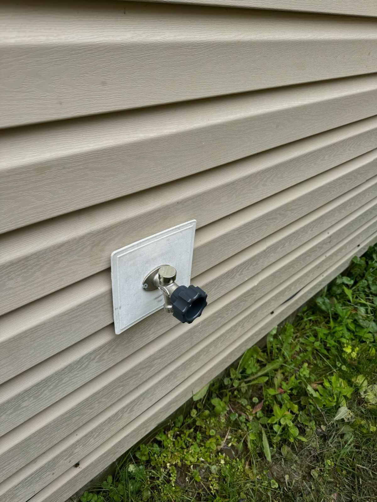 A faucet is attached to the side of a house.