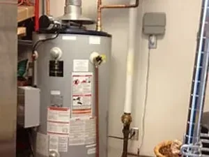 A water heater is sitting in a room next to a ladder.