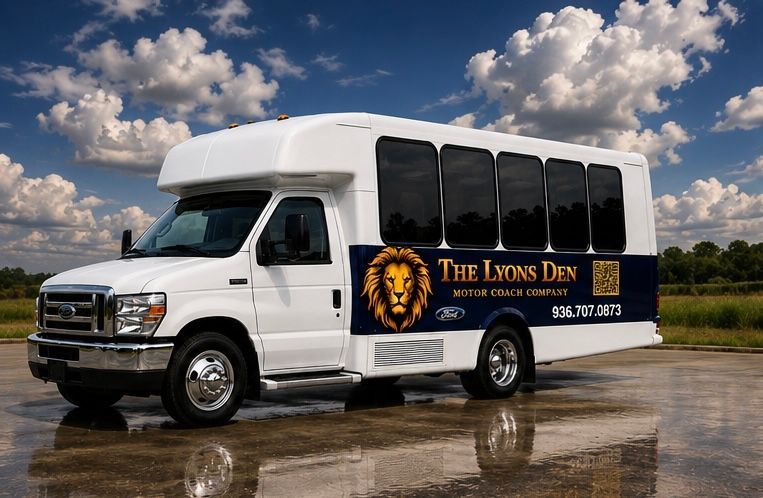 White shuttle bus with “The Lion’s Den” logo parked on a wet road under a cloudy sky
