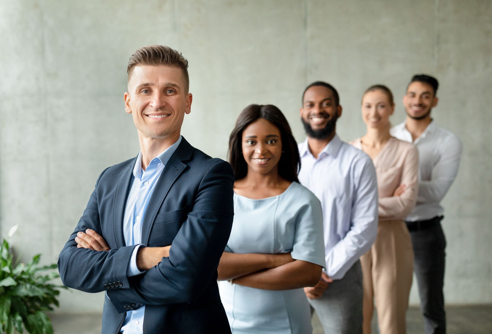 Group of professionals standing in a line with arms crossed in a modern office setting. Group of professionals standing in a line with arms crossed in a modern office setting.