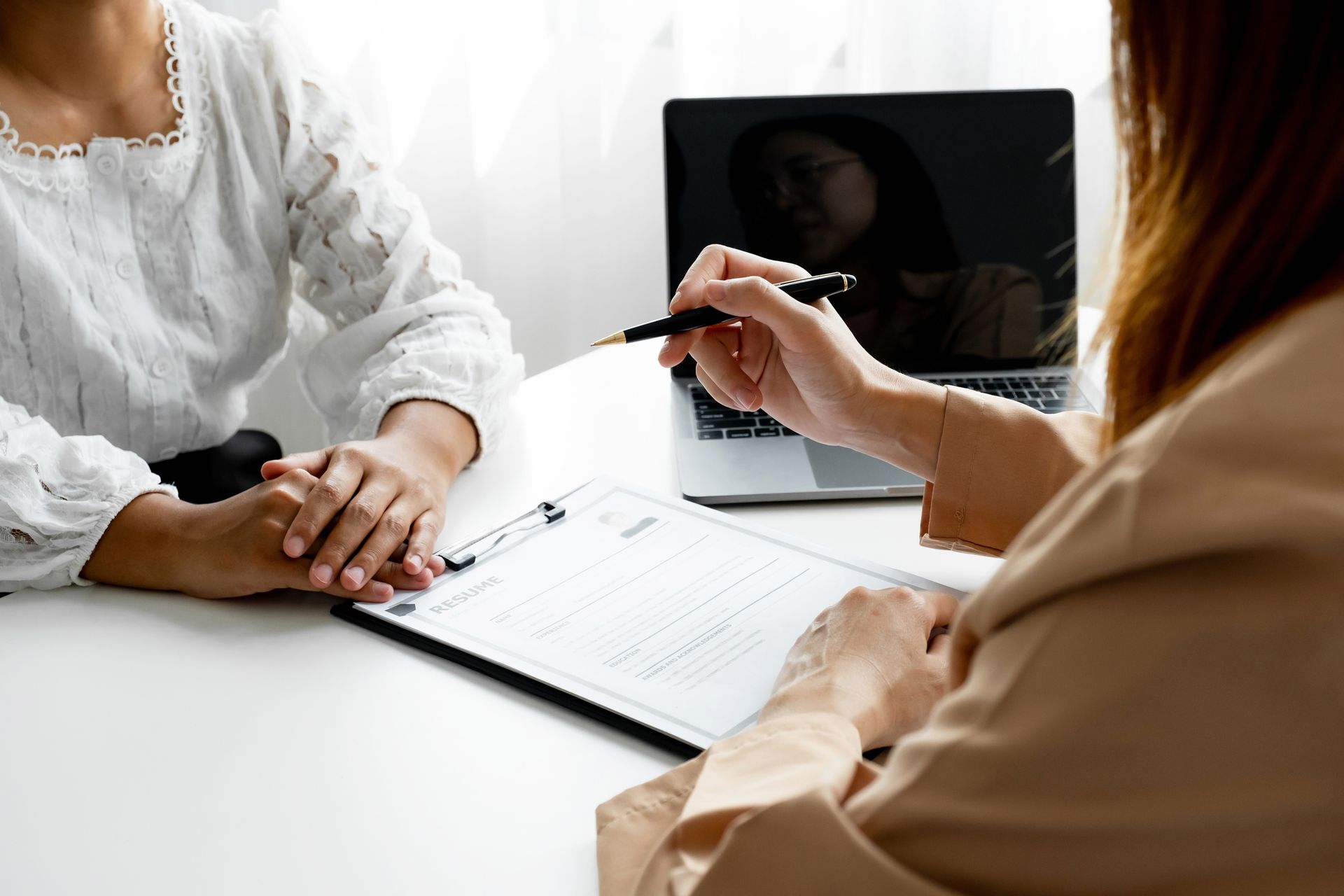 A woman is interviewing an applicant in a meeting room.