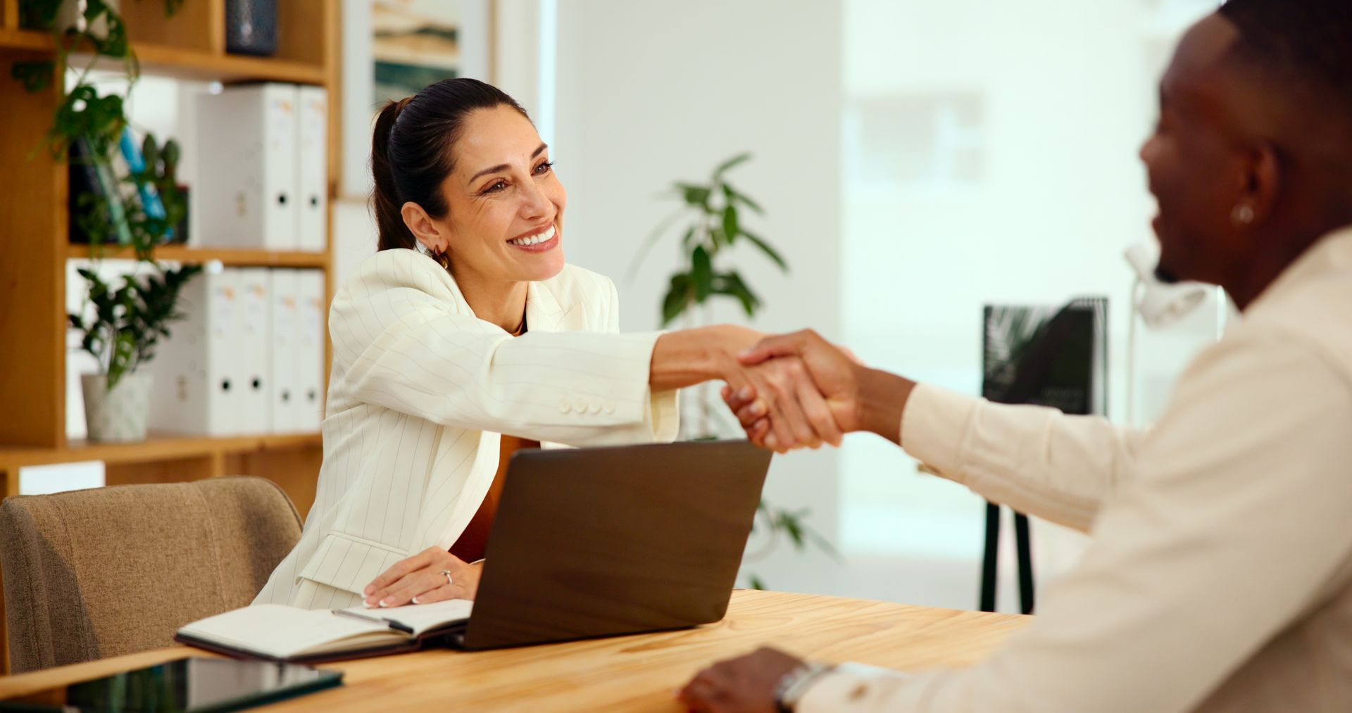 A woman is shaking the hand of a man in an office. A woman is shaking the hand of a man in an office.