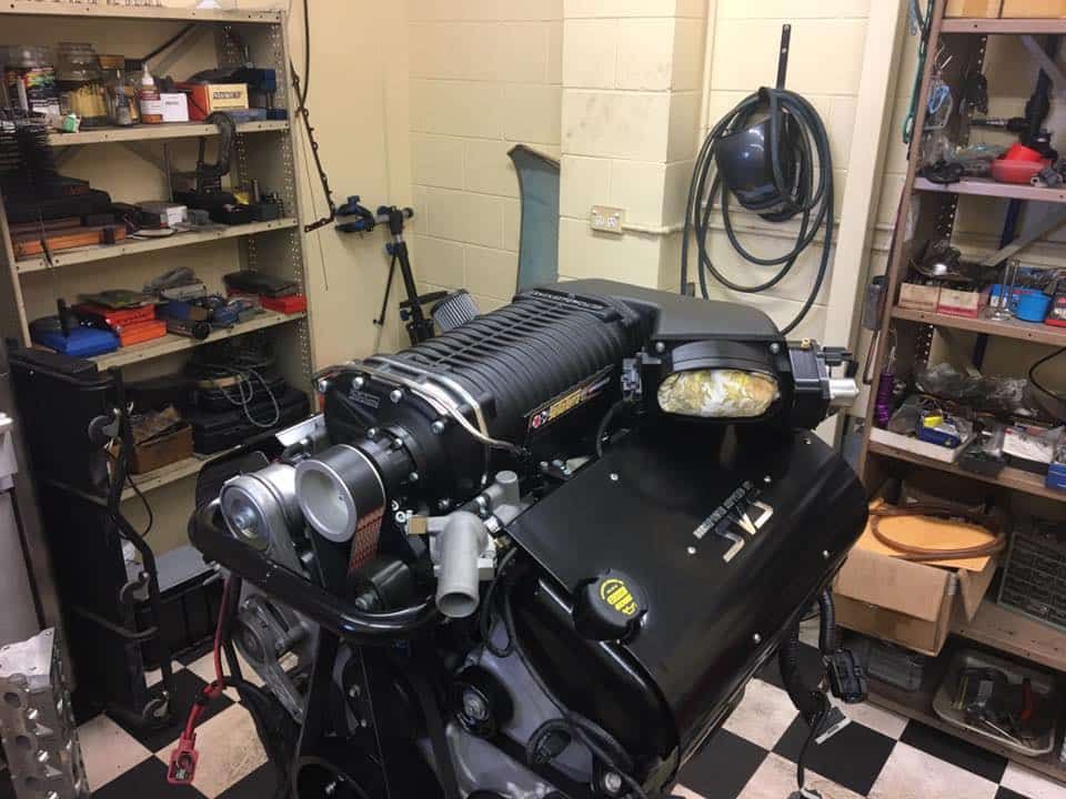 A Black Engine is Sitting in a Garage With a Checkered Floor — SVS Auto Repairs & Dyno Tuning in Bungalow, QLD