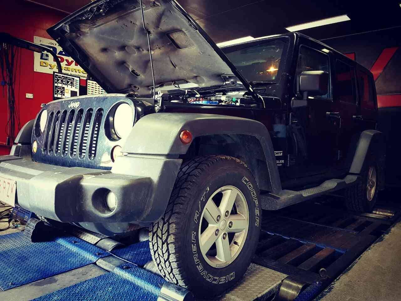A Jeep With Its Hood Up is Sitting on a Ramp in a Garage — SVS Auto Repairs & Dyno Tuning in Weipa, QLD