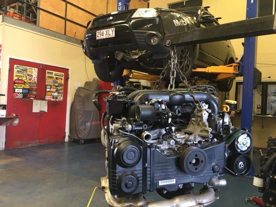 A Car Engine is Hanging From a Crane in a Garage — SVS Auto Repairs & Dyno Tuning in Cairns, QLD