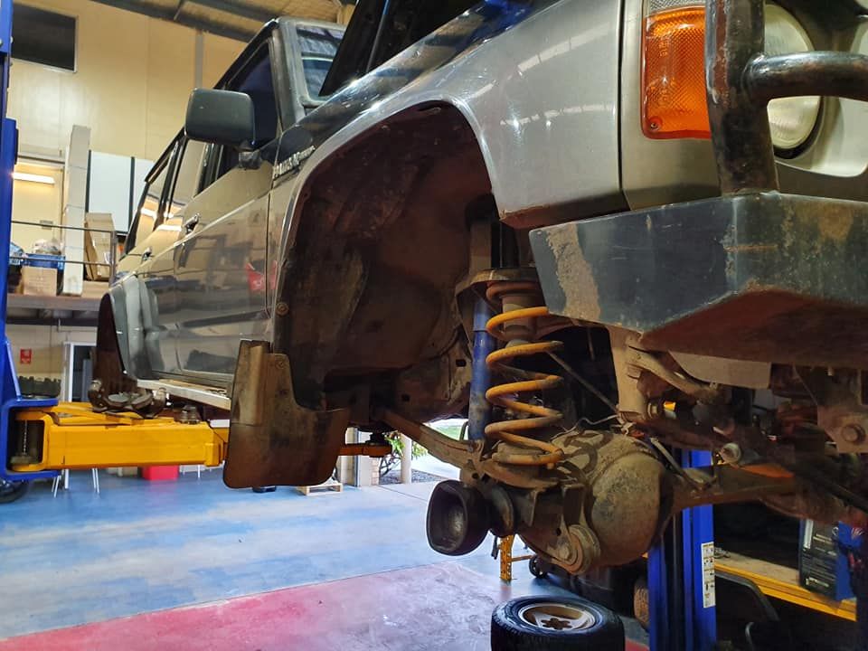 A Car is Sitting on a Lift in a Garage — SVS Auto Repairs & Dyno Tuning in Bungalow, QLD