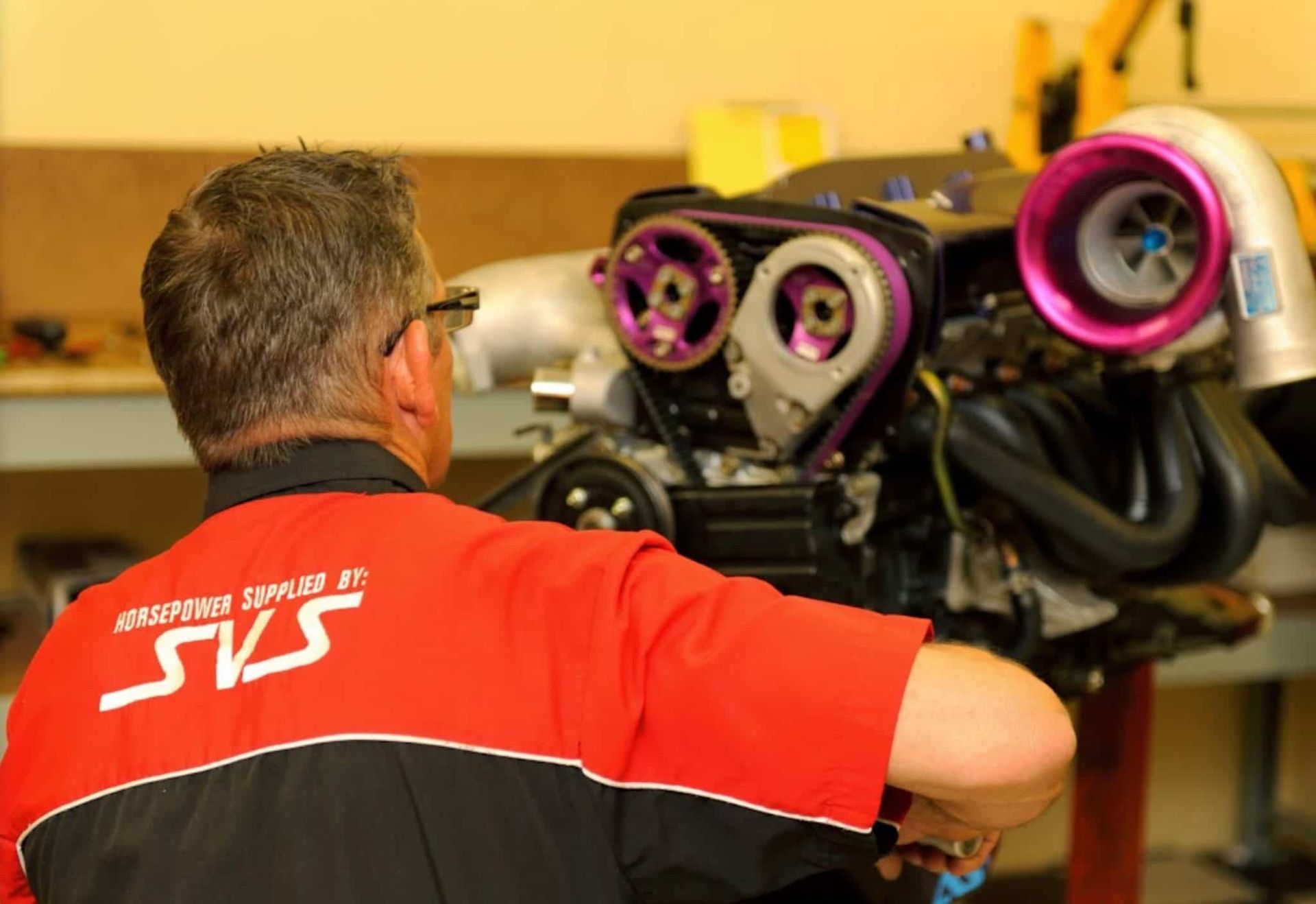 A Man Wearing a SVS Shirt is Working on a Car Engine — SVS Auto Repairs & Dyno Tuning in Weipa, QLD