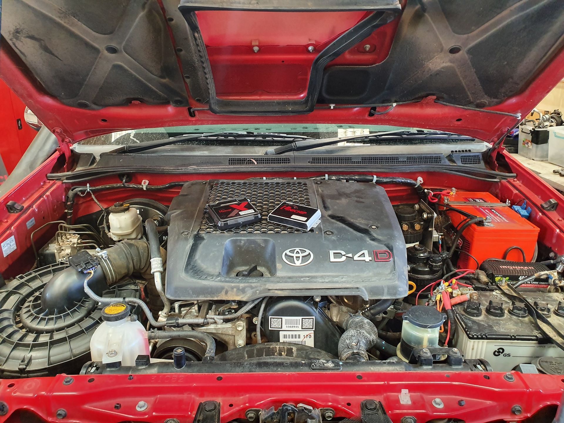 The Engine of a Red Toyota is Shown With the Hood Open — SVS Auto Repairs & Dyno Tuning in Bungalow, QLD