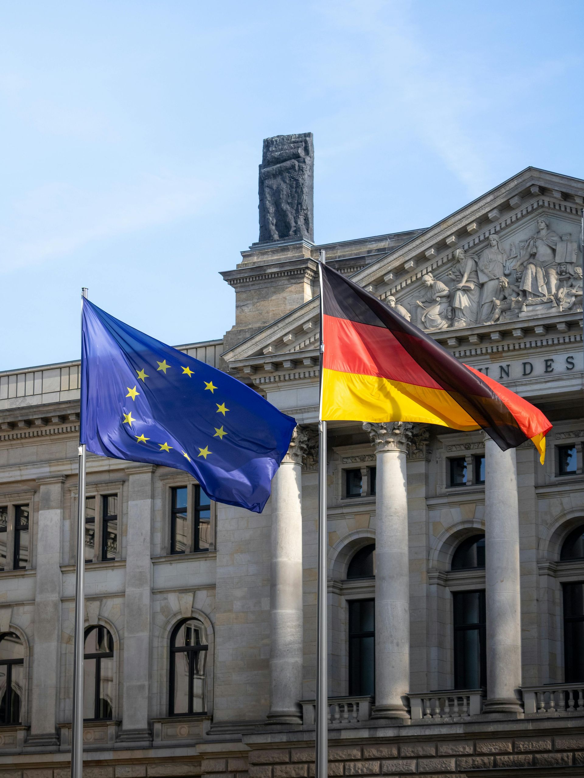 Deutscher Bundestag, vor dem eine EU- und eine Deutschlandflagge wehen