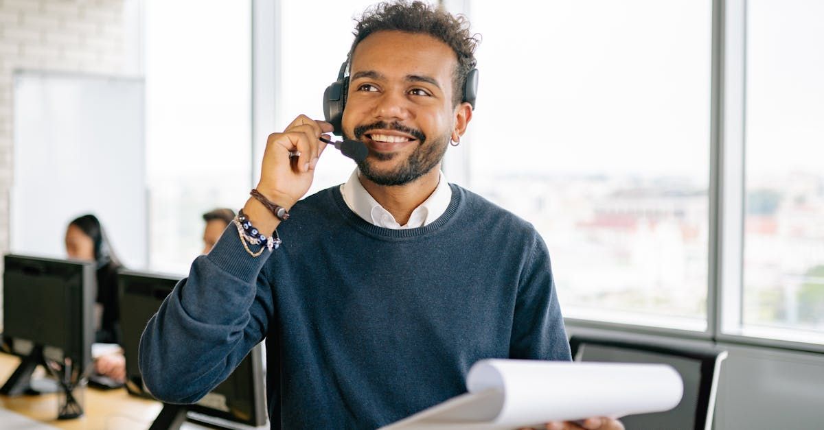 A man is talking on a headset while holding a piece of paper.