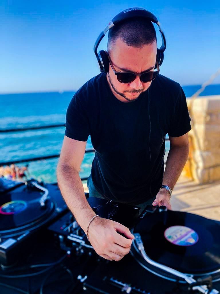 Un uomo che indossa le cuffie sta riproducendo un disco su un giradischi.