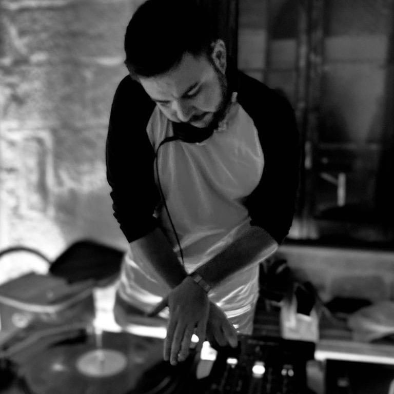 Un uomo sta suonando un disco su un giradischi in una foto in bianco e nero