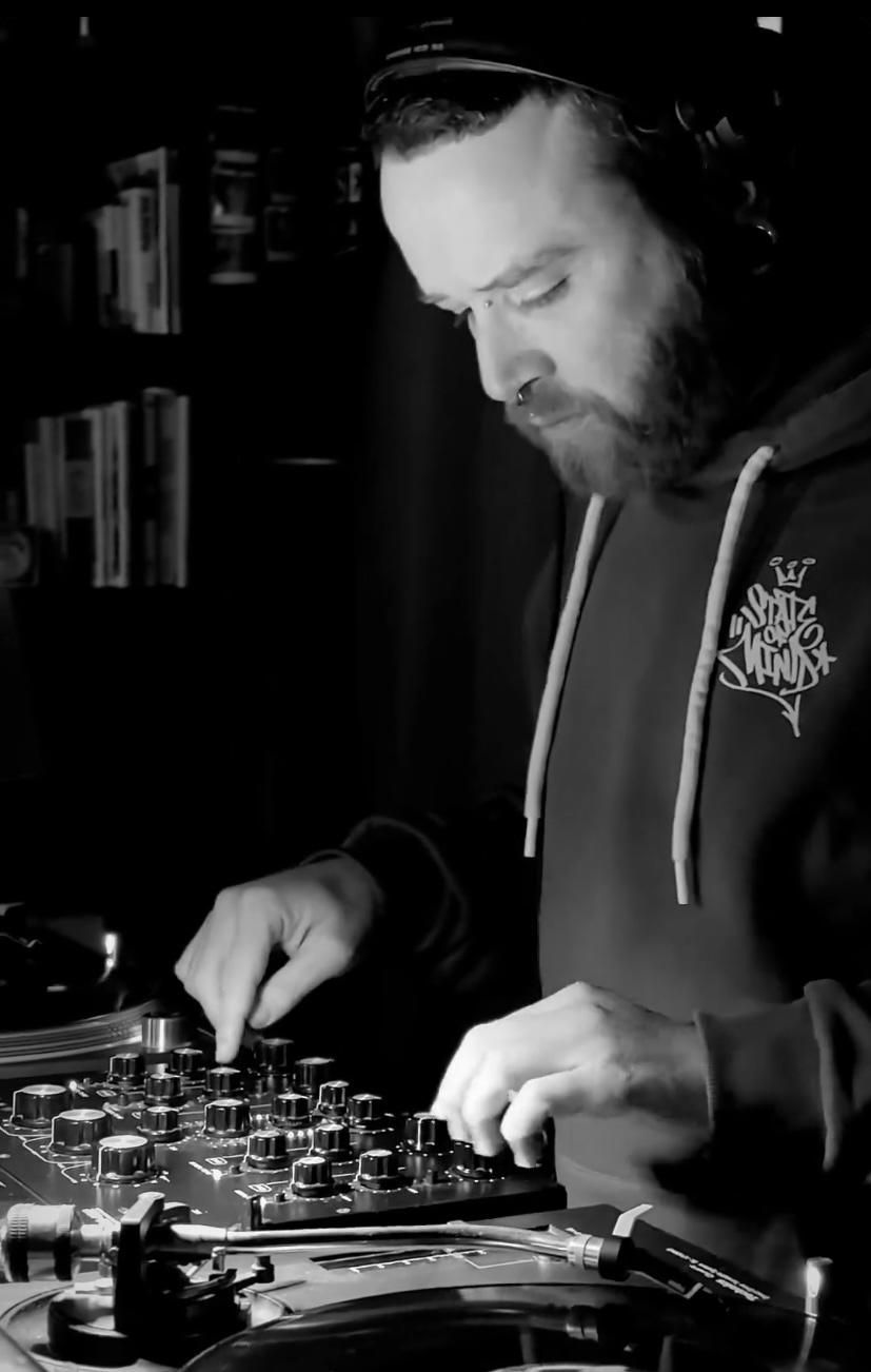 Un uomo è seduto a un tavolo con un computer portatile e delle cuffie.