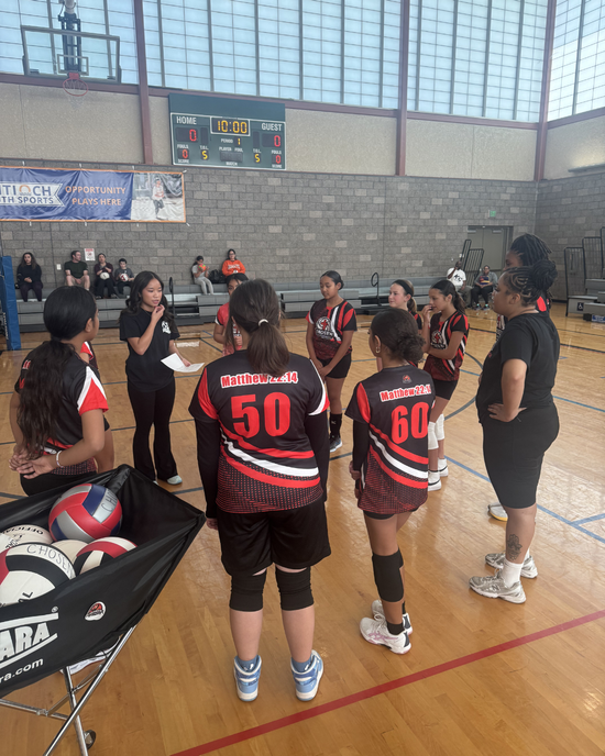 Baseball glove with ball on green grass, with blurred baseballs in the background.