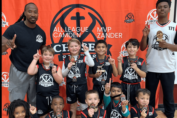 Baseball player sliding into home plate, catcher in front. Blue and gold uniforms, action shot.