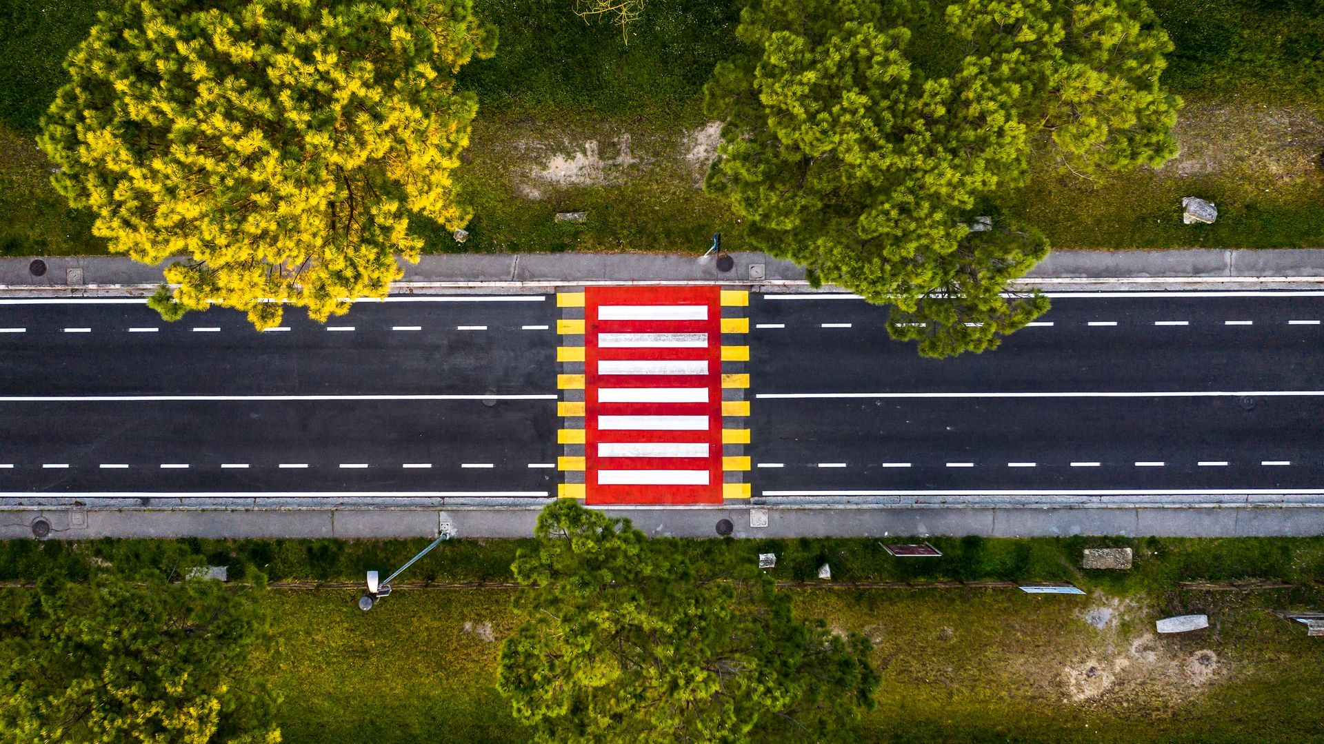 Vista dall'alto di una strada con attraversamenti pedonali rossi e bianchi